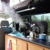 A boiling kettle on the gas hob, next to the sink. A boiling kettle on the gas hob, next to the sink.